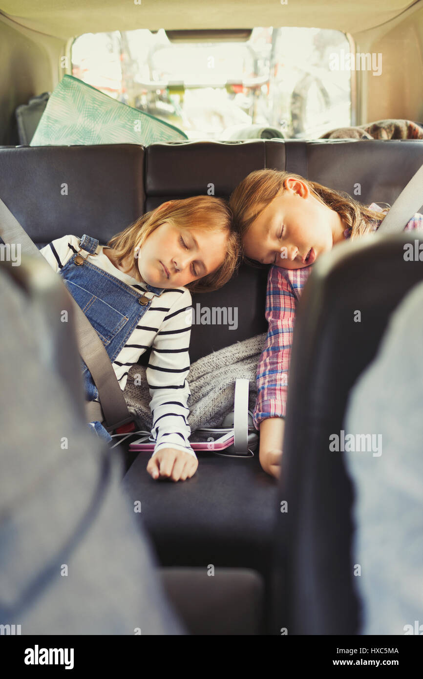 Soeurs fatigué dormir dans siège arrière de voiture Banque D'Images