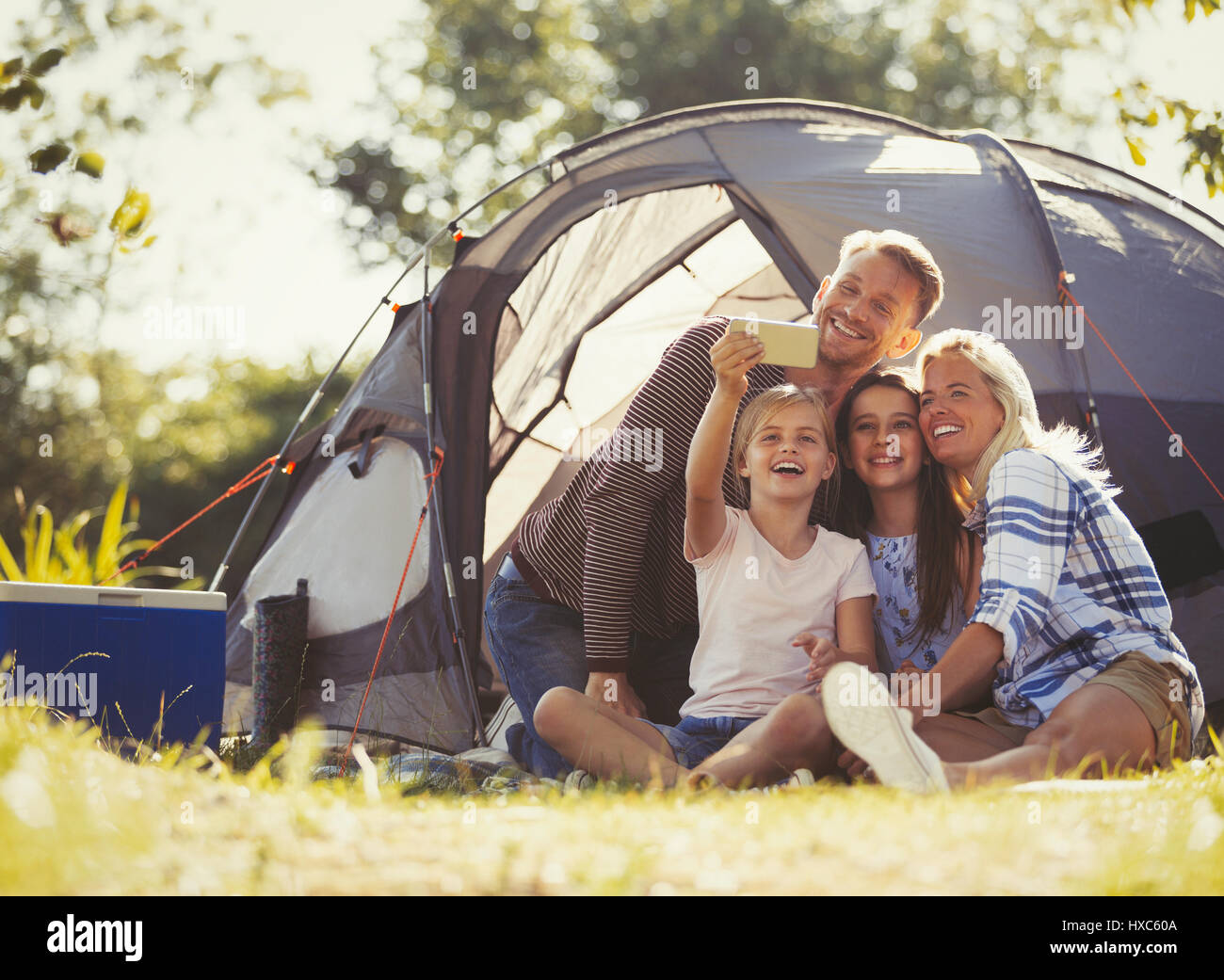 En famille avec selfies téléphone appareil photo à l'extérieur tente de camping Banque D'Images