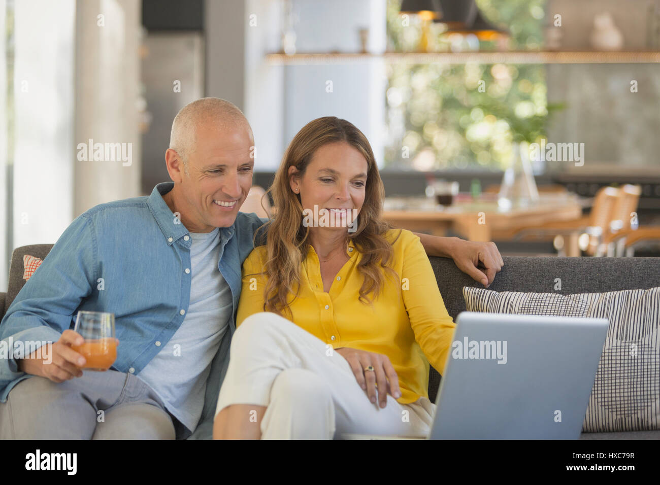 Couple, à l'aide de l'ordinateur portable sur salon canapé Banque D'Images