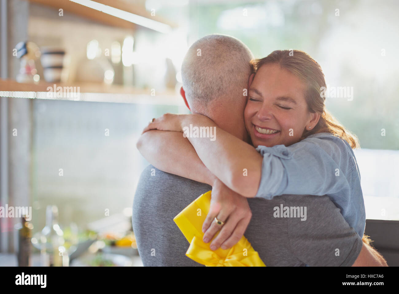 Heureux couple hugging in kitchen Banque D'Images