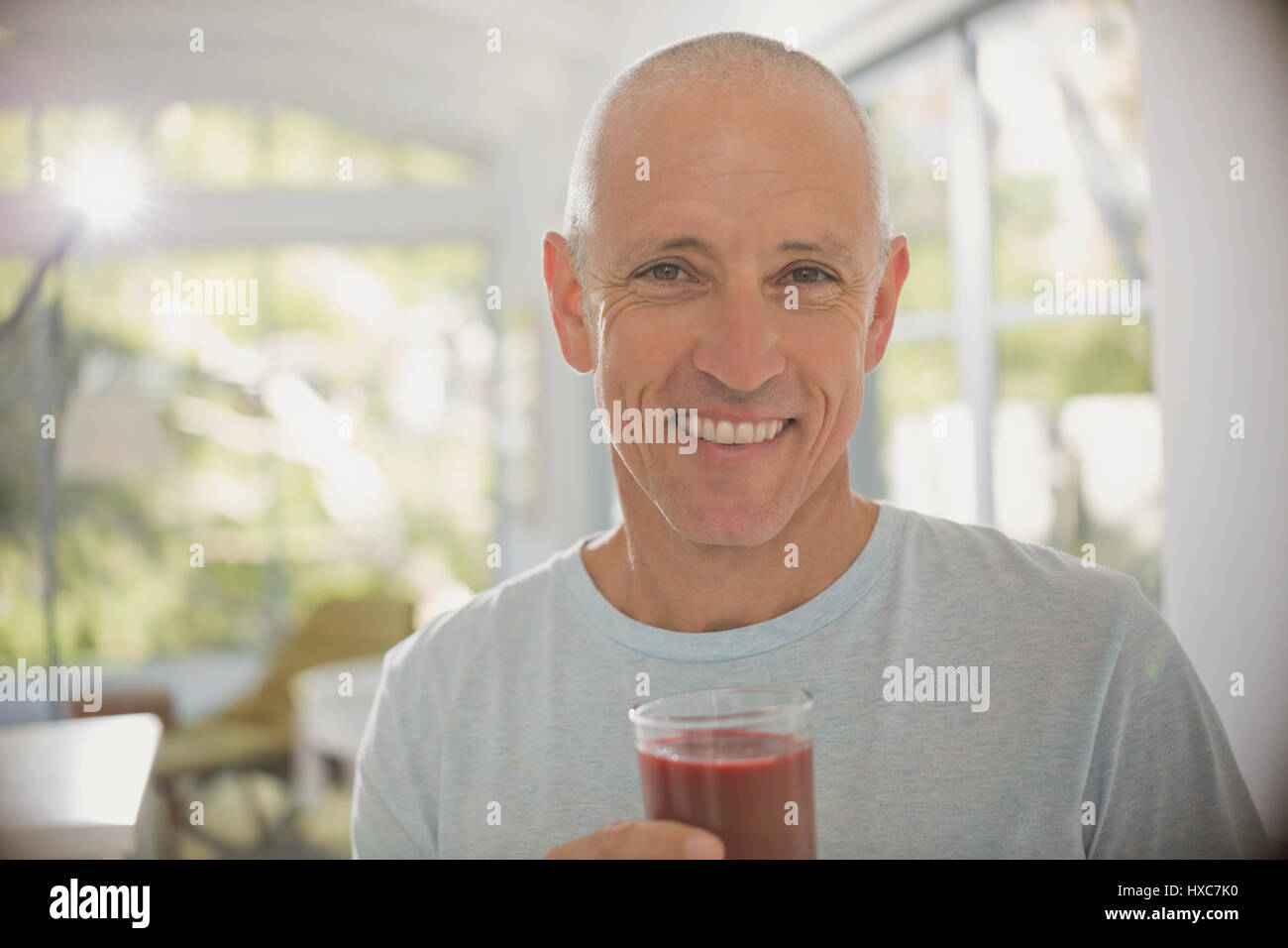 Portrait souriant, confiant mature man drinking smoothie aux fruits sains Banque D'Images