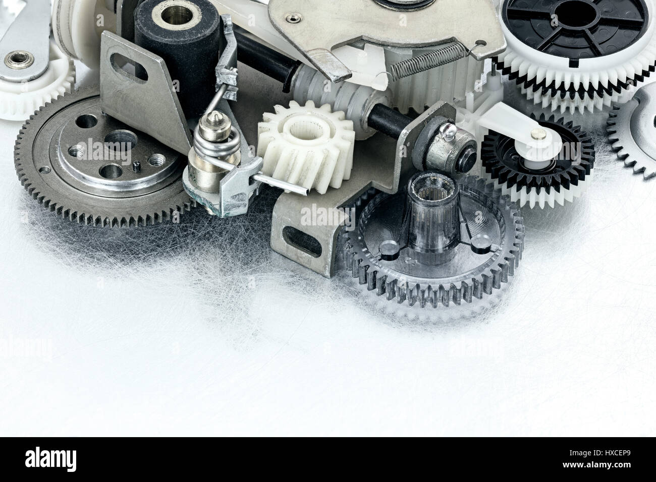 Roues dentées en métal et en plastique et d'autres parties de machines industrielles sur fond rayé Banque D'Images
