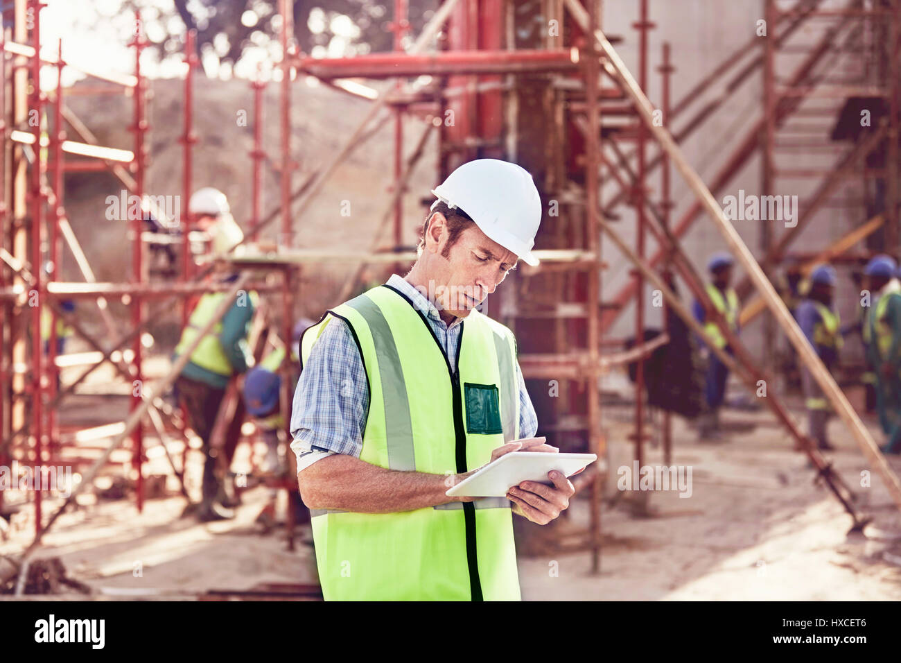 Construction Worker using digital tablet at construction site Banque D'Images