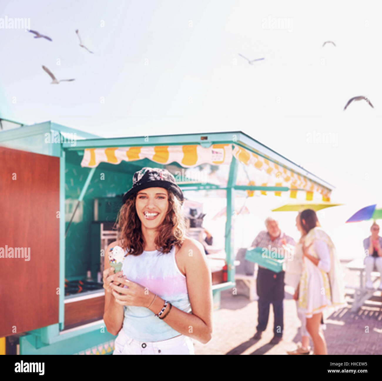Portrait of smiling young woman enjoying ice cream en dehors des aliments panier ensoleillé Banque D'Images