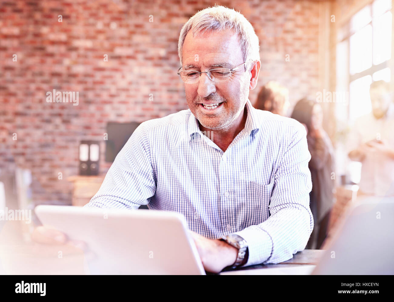 Smiling businessman using digital tablet in office Banque D'Images