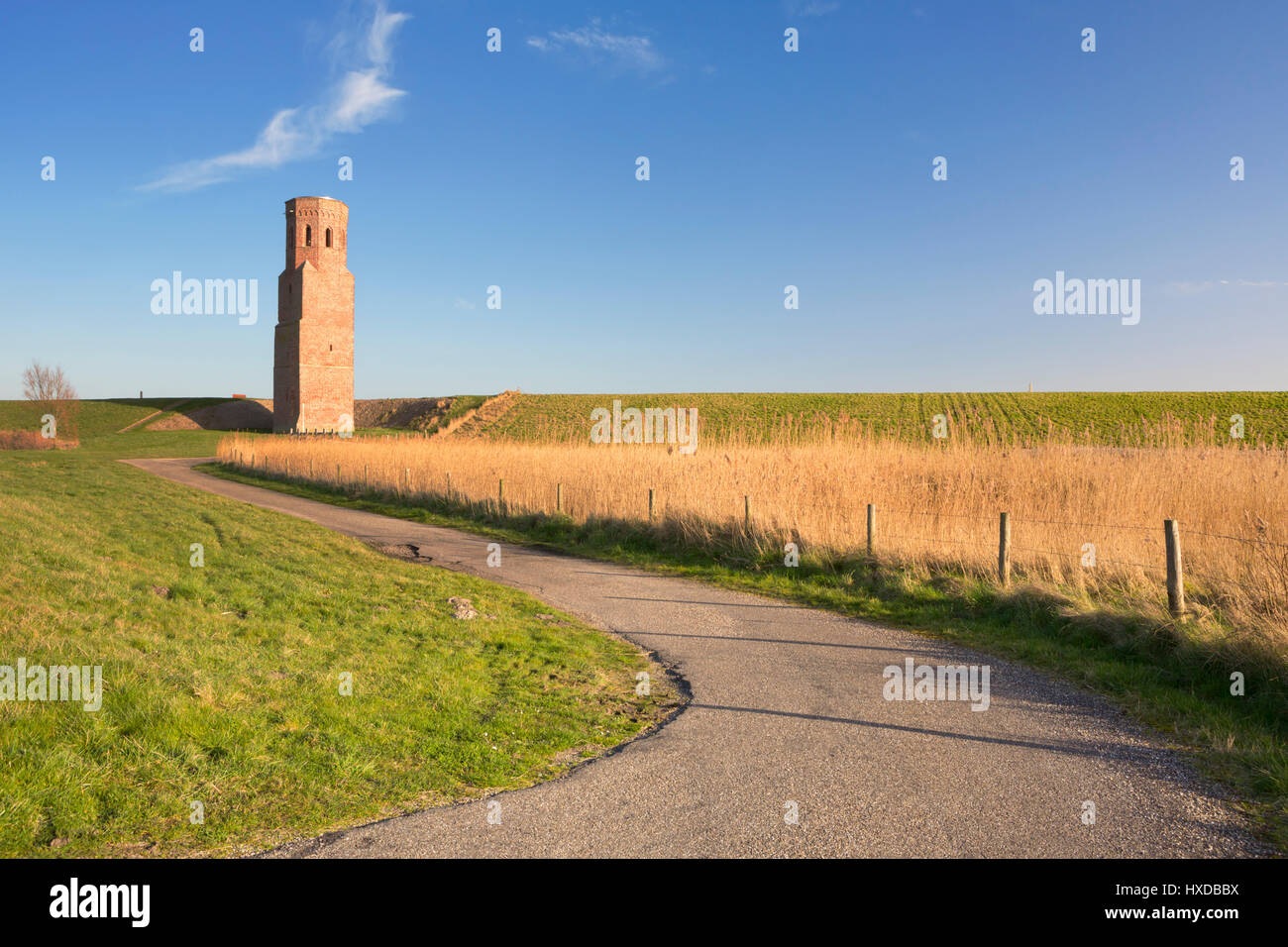 L'Plompe Toren tour de l'église derrière la digue de l'Escaut oriental en Zélande, aux Pays-Bas. Photographié à la fin de l'après-midi du soleil. Banque D'Images