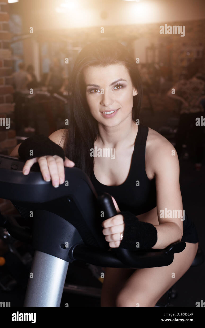 Muscular young woman wearing sportswear formation sur les vélos d'exercice dans la salle de sport. Entraînement cardio intense Banque D'Images