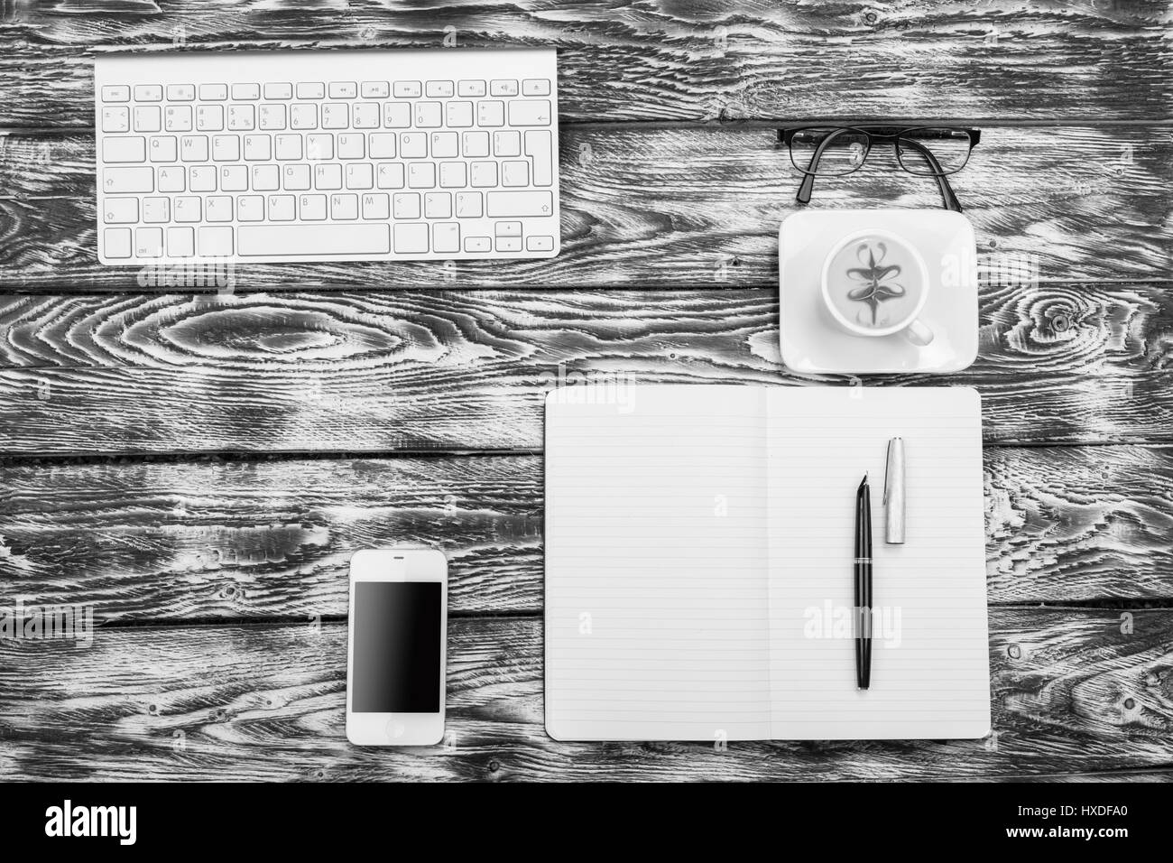 Noir et blanc à contraste élevé lieu de travail Vue de dessus : clavier, café, téléphone mobile Banque D'Images