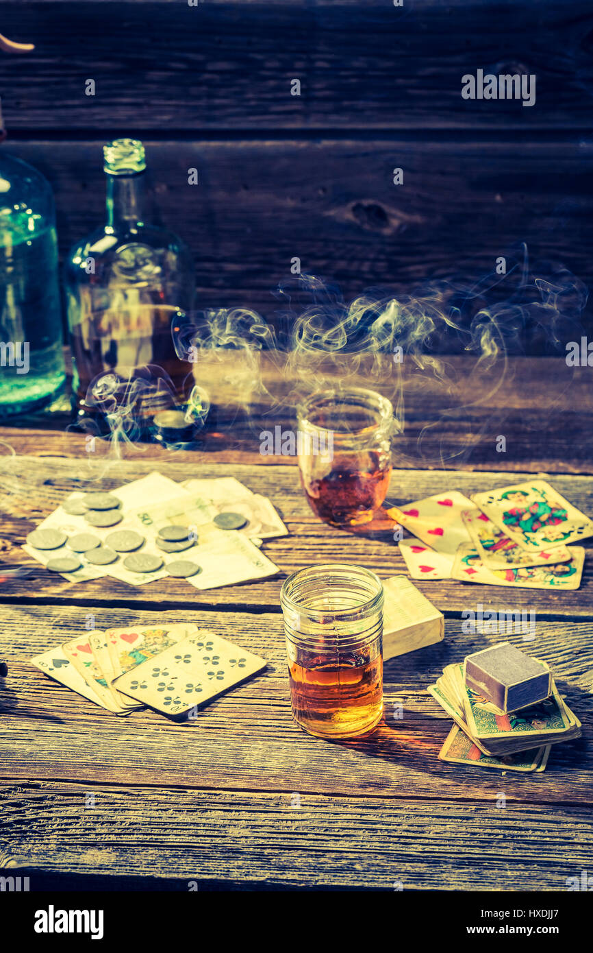 Vodka, cigarettes et cartes sur table de poker illégales de vieux Banque D'Images