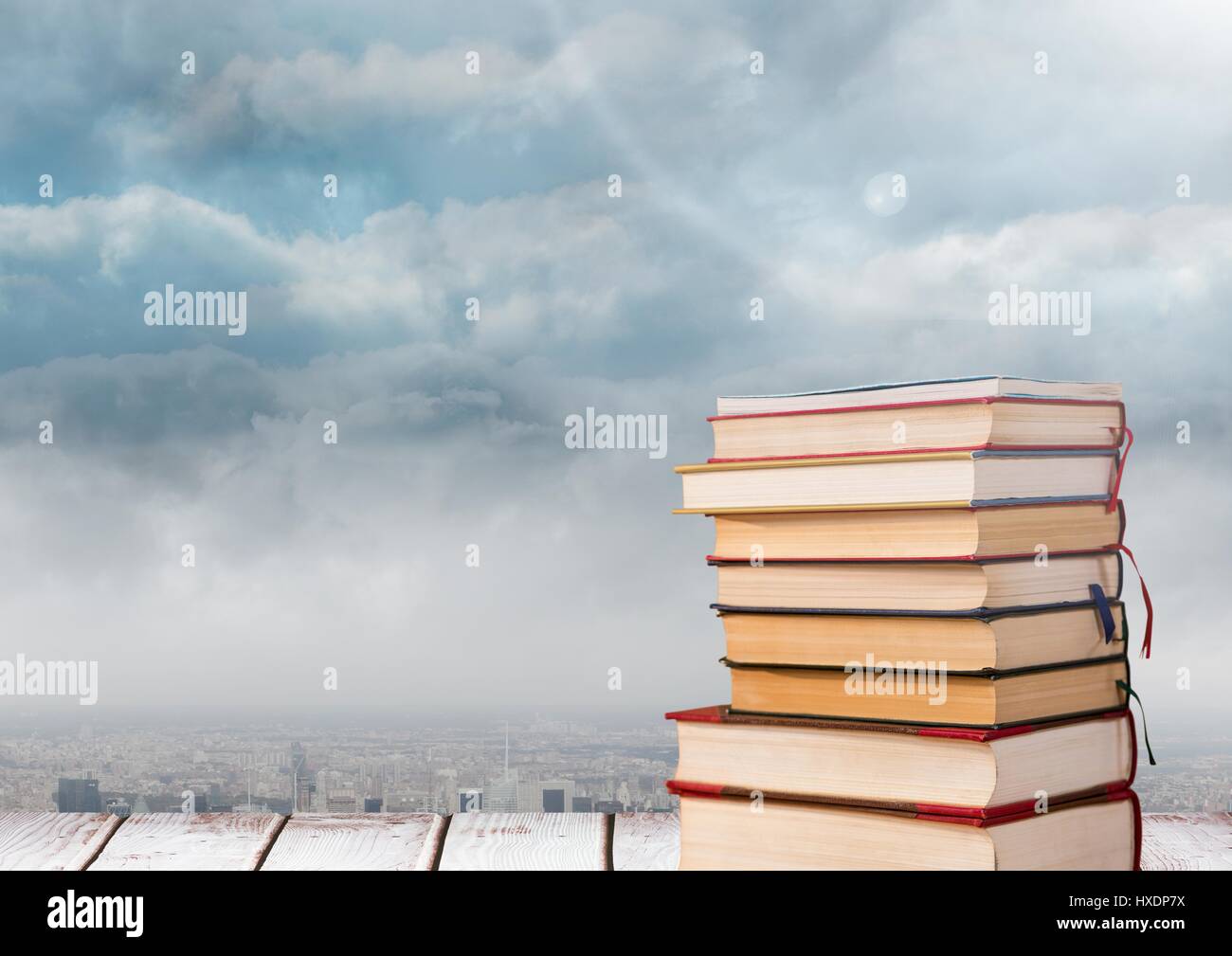 Composite numérique de livres empilés par les nuages Banque D'Images
