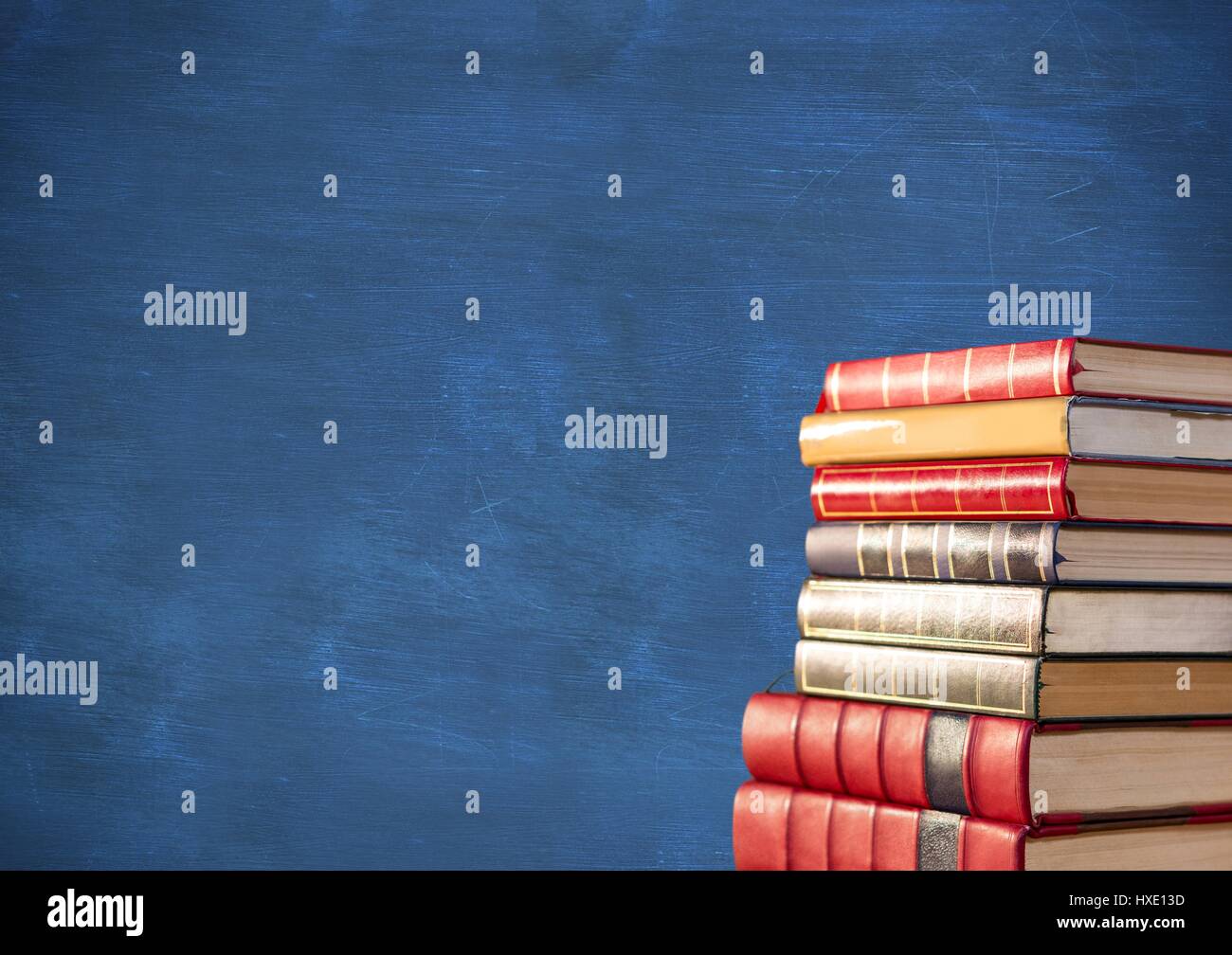 Digital composite de pile de livres contre tableau bleu Banque D'Images