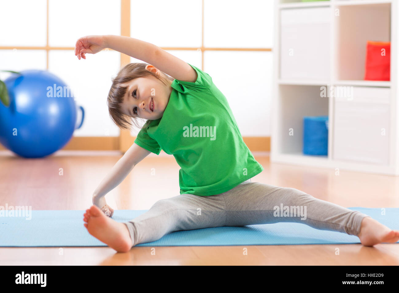 Sportive kid girl doing gymnastic à la maison Banque D'Images