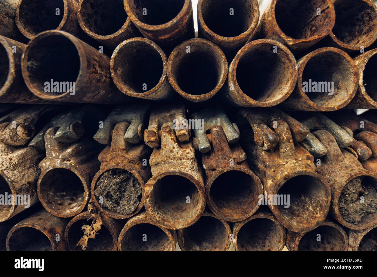 Old rusty utilisé des tuyaux en acier échafaudage empilés sur le site de construction, selective focus Banque D'Images