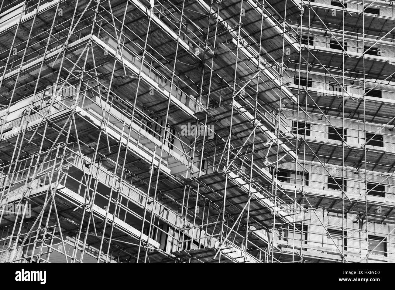 La vie moderne maison est en construction, l'immeuble de fragment d'échafaudages de façade structures, photo en noir et blanc Banque D'Images