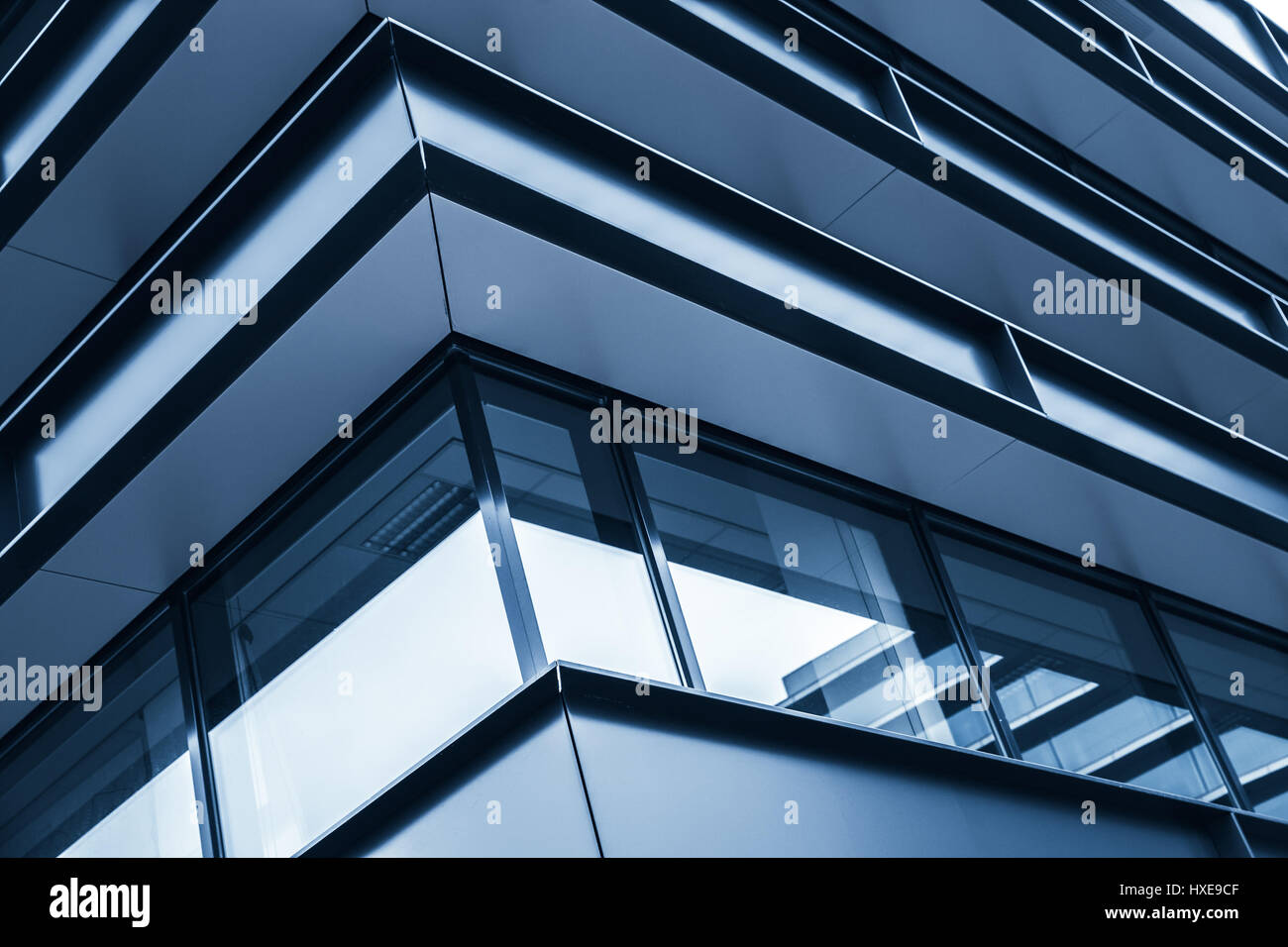 Coin de la façade de l'immeuble moderne, résumé fragment, structure en acier brillant fenêtres dans les tons bleus, fond photo Banque D'Images