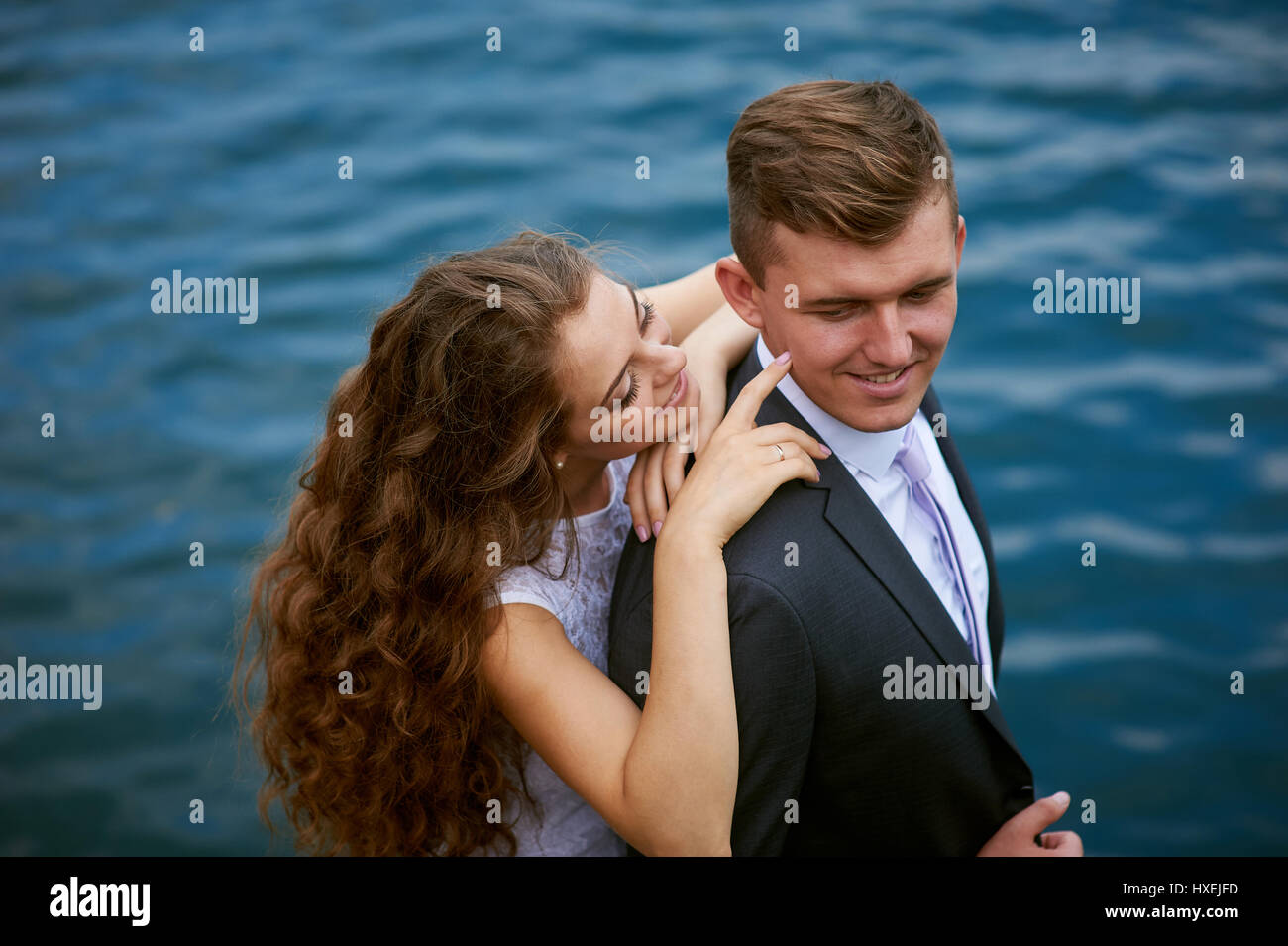 Jeune couple aimant sur une promenade près du lac le jour de leur mariage Banque D'Images