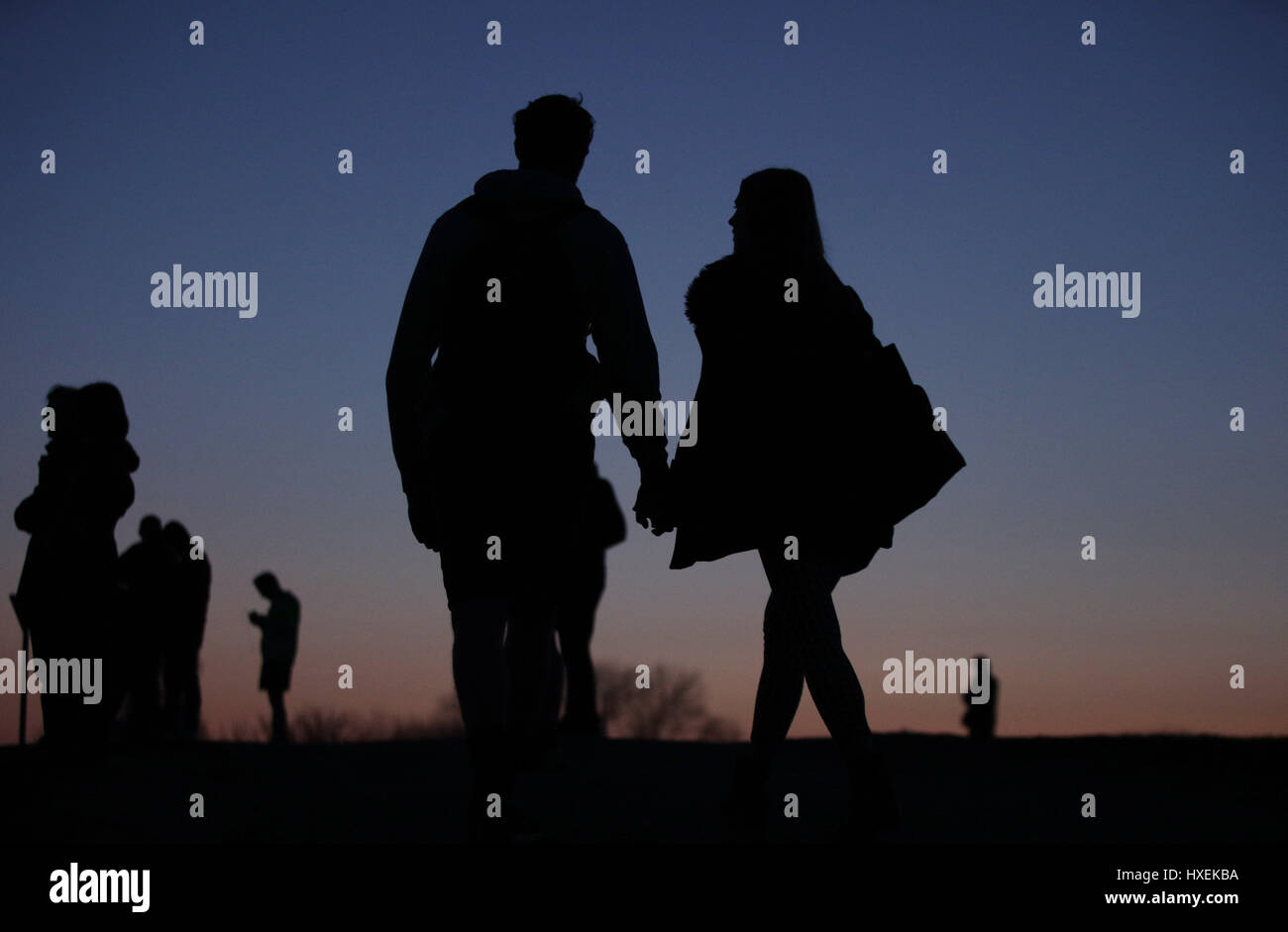 Les silhouettes d'un couple holding hands au crépuscule sur la Colline du Parlement, Hampstead Heath, au nord de Londres. Banque D'Images