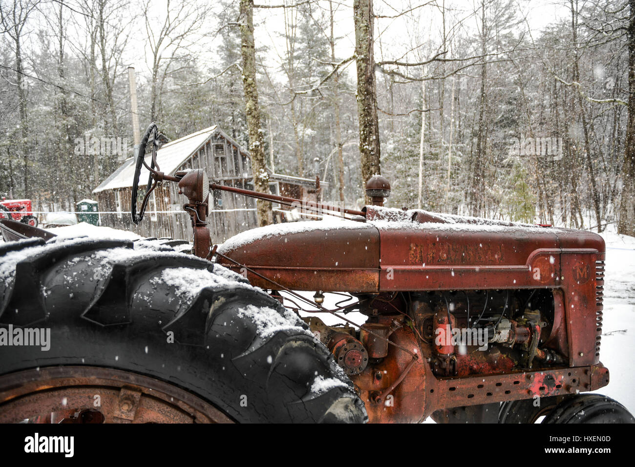 Tracteur rouge rouillé dans la neige sur une ferme de la Nouvelle Angleterre Banque D'Images
