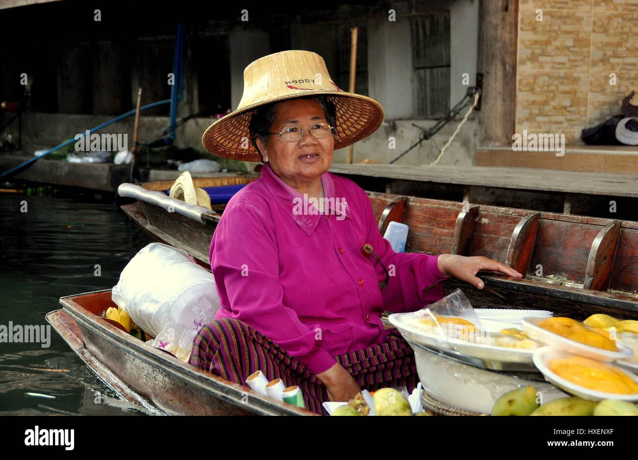 Damnoen Saduak, Thaïlande - 9 janvier 2010 : femme vendant de délicieux produits frais mangues tropicales de son bateau comme elle le long d'un canal des palettes flottantes à la Banque D'Images