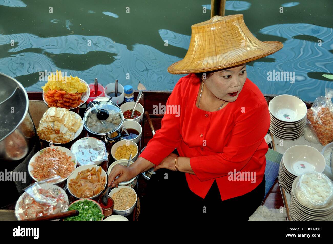 Damnoen Saduak, Thaïlande - 9 janvier 2010 : Femme en chapeau de paille vendent de délicieux aliments thaïlandais à bord de son bateau flottant de Damnoen Saduak à la Mar Banque D'Images