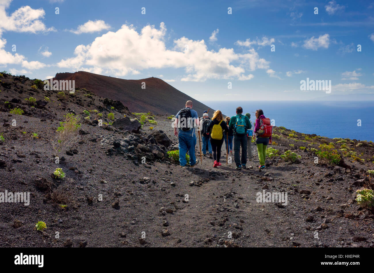 Les touristes le long d'un chemin de randonnée sur une visite guidée dans la région de la Cumbre Vieja, Fuencaliente de La Palma. Le paysage est la roche de lave créé par les volcans dans la région. Très peu de végétation est capable de croître sur cette terre Barron. Banque D'Images