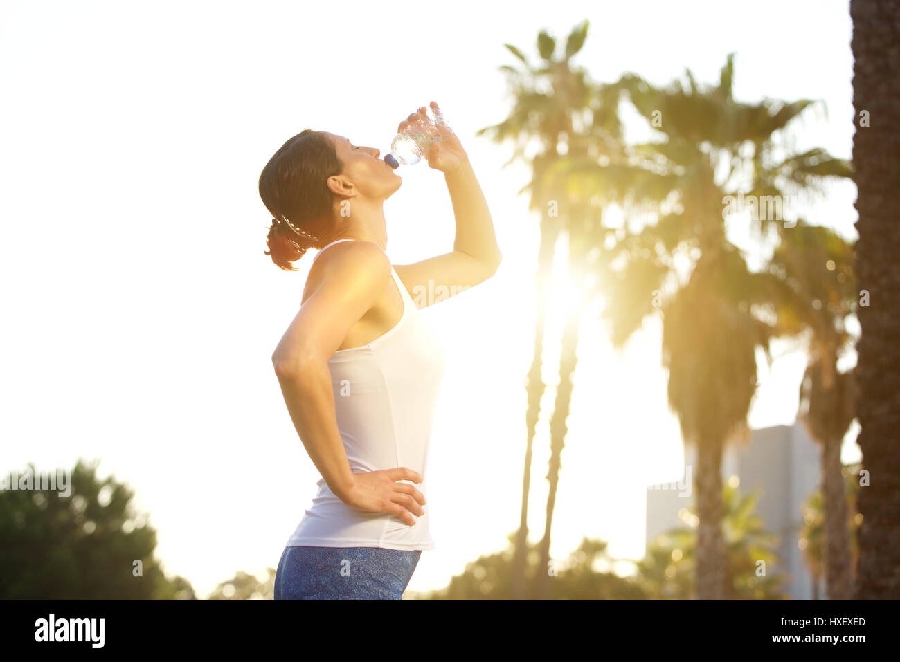 Portrait d'un côté femme sports l'eau potable de la bouteille après entraînement Banque D'Images