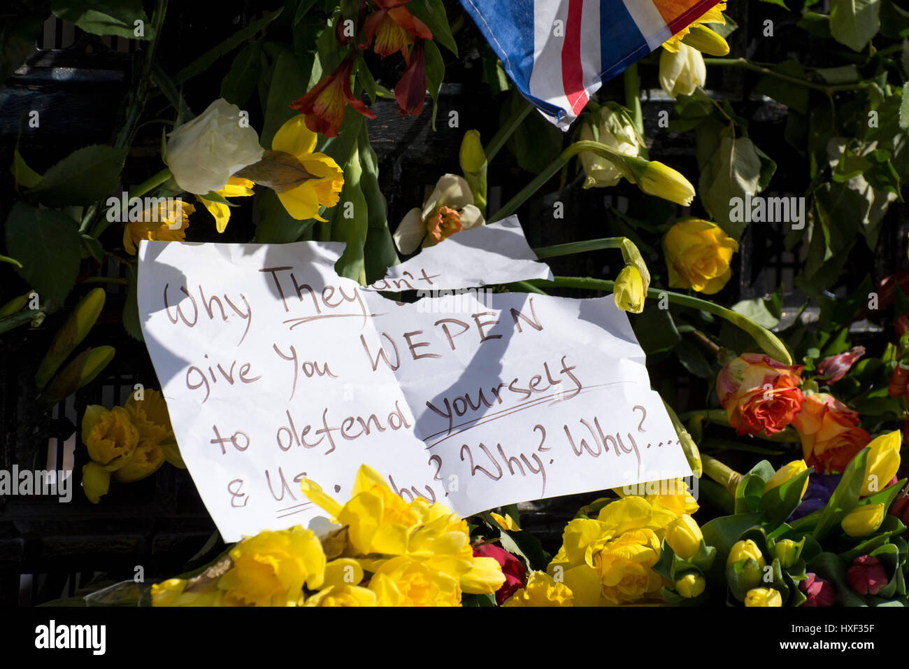 Note laissée sur les fleurs se référant à PC Keith Palmer et rencontré les agents de police : "pourquoi elles ne vous donneront pas wepen pour vous défendre et nous. Pourquoi ? Pourquoi ? Pourquoi ?" Banque D'Images