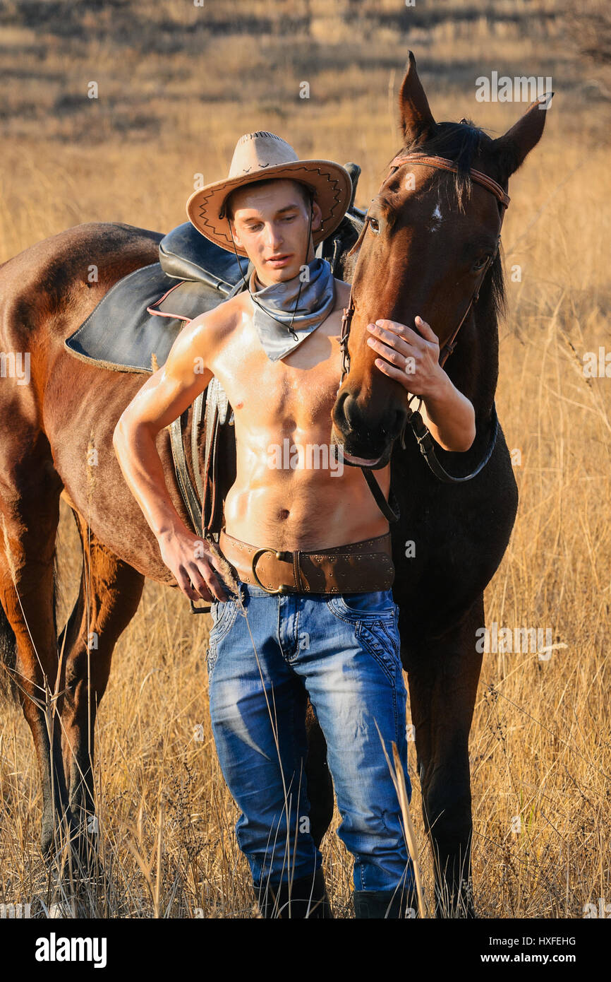 Cowboy avec un cheval à un dimanche d'été Banque D'Images
