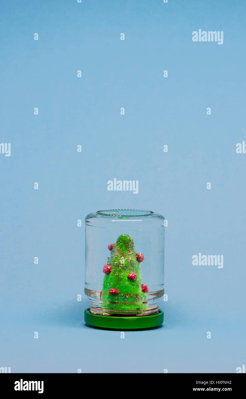 Snow globe avec un arbre de Noël selfmade dans un bocal rempli d'eau. Arborescence constituée d'argile verte. Banque D'Images