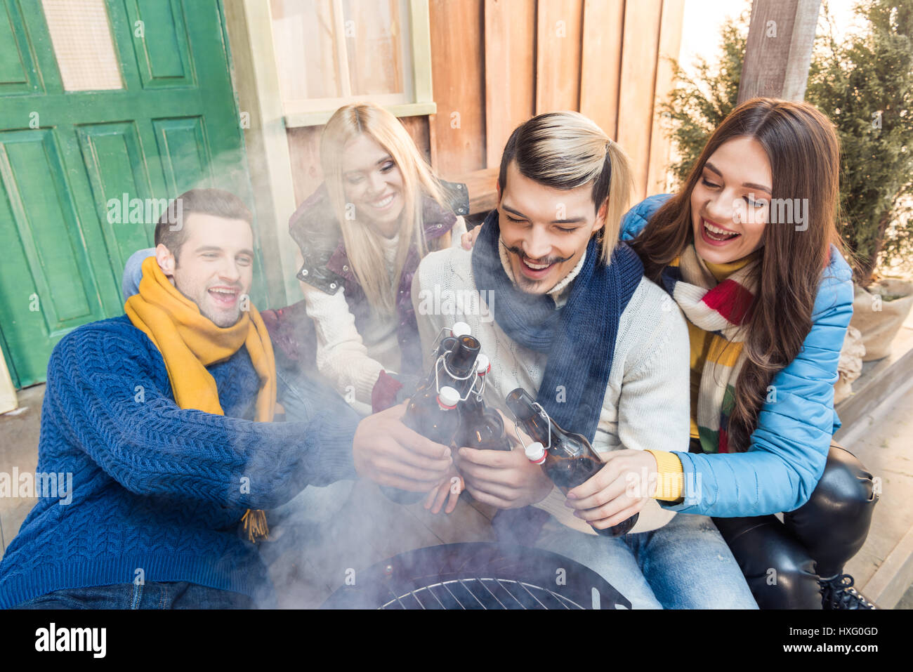 High angle view of woman sitting on porch avec de la bière sur le barbecue Banque D'Images