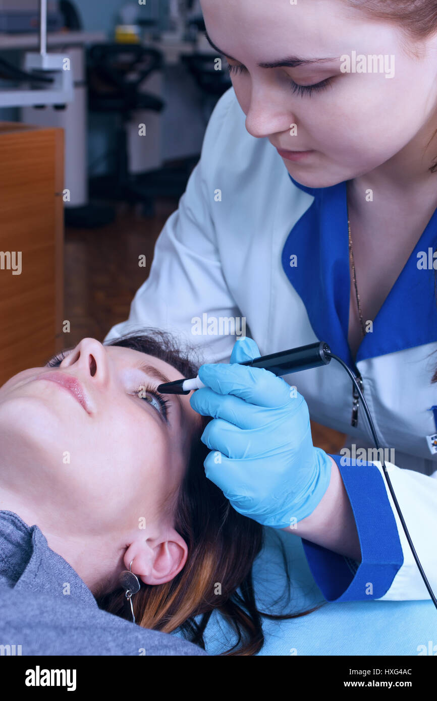 Ophtalmologue effectue une opération pour diagnostiquer la vision d'une jeune fille. Banque D'Images