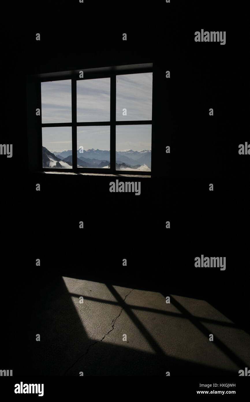 Vue de paysage de montagnes qui entourent le Mont Blanc par la fenêtre avec la lumière qui tombe sur le sol de la Chambre la création d'une grille comme l'ombre Banque D'Images