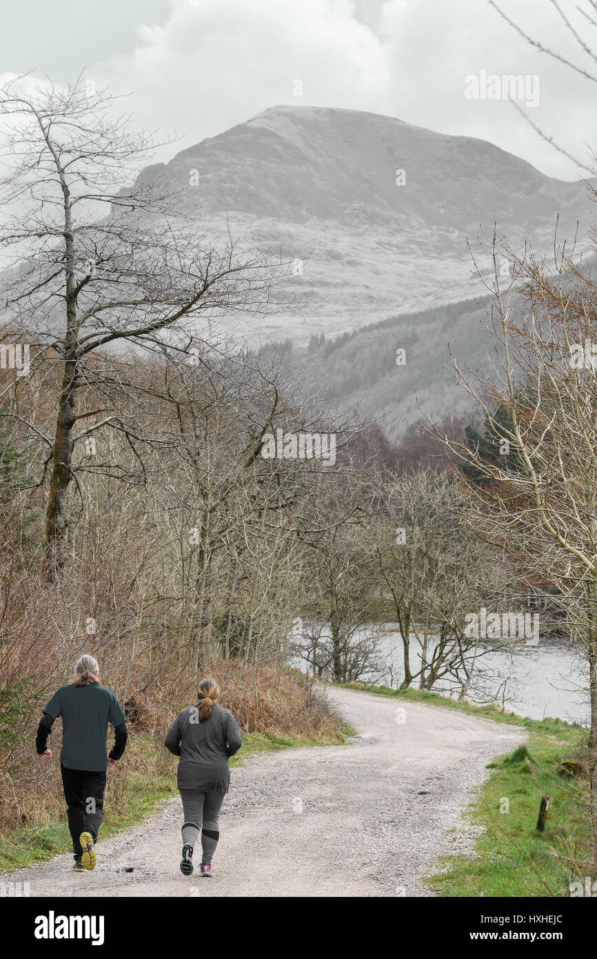 Un couple de coureurs sur un chemin d'accès à l'eau (lac) Ennerdale, Lake District, Cumbria, Angleterre. Banque D'Images