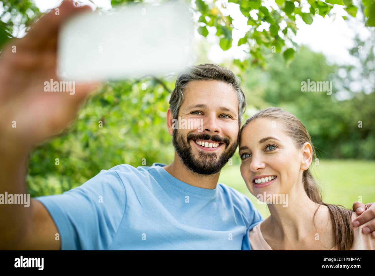 Couple heureux en amour en tenant avec smartphone selfies Banque D'Images