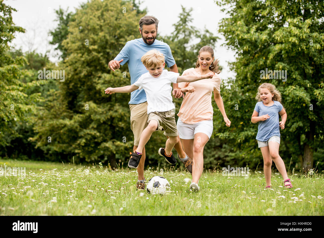 Famille joue au soccer dans le parc et s'amusant Banque D'Images