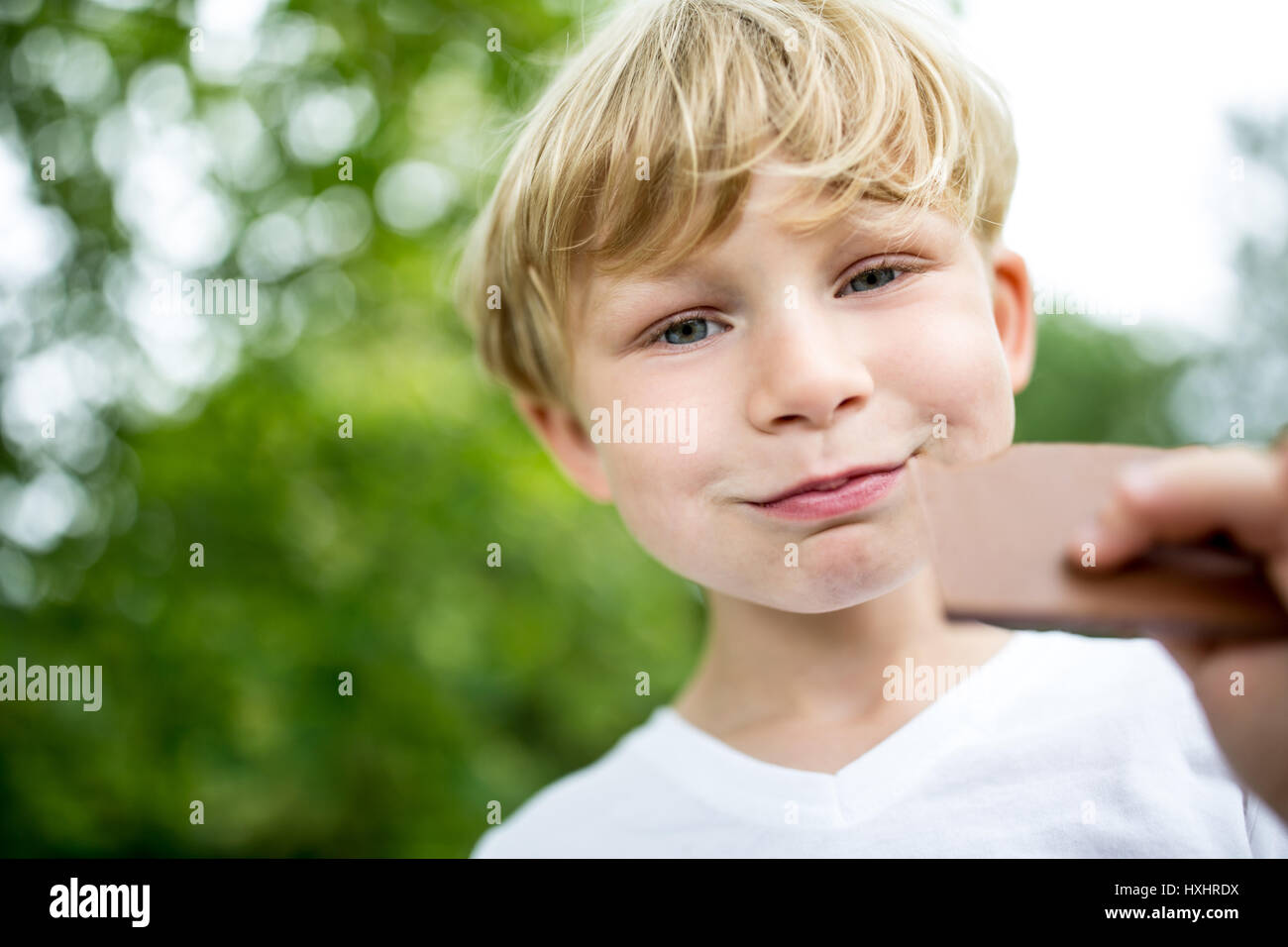 Happy child eating chocolate cookie en été au parc Banque D'Images