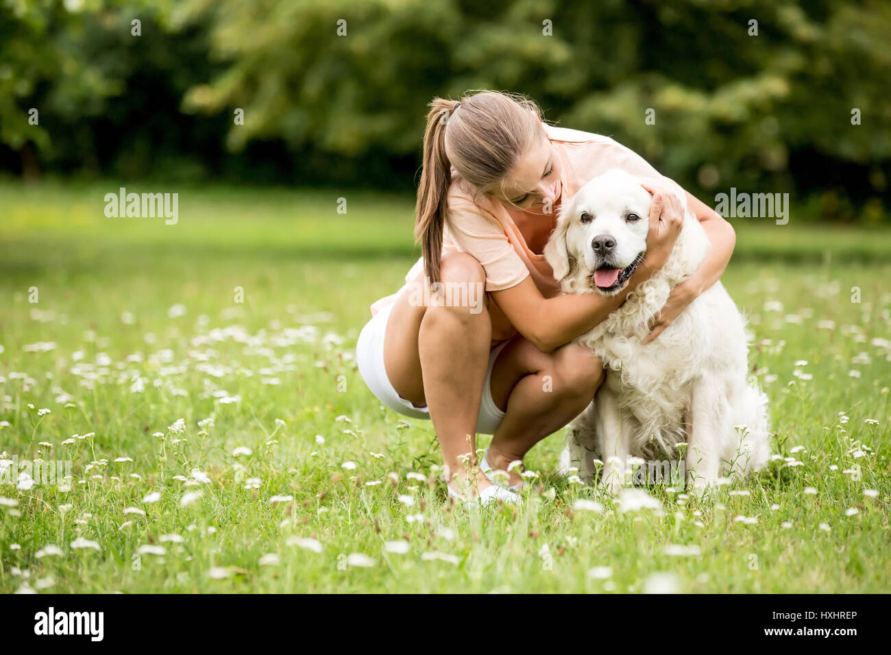 Femme câline son ami chien Golden Retriever en été au jardin Banque D'Images