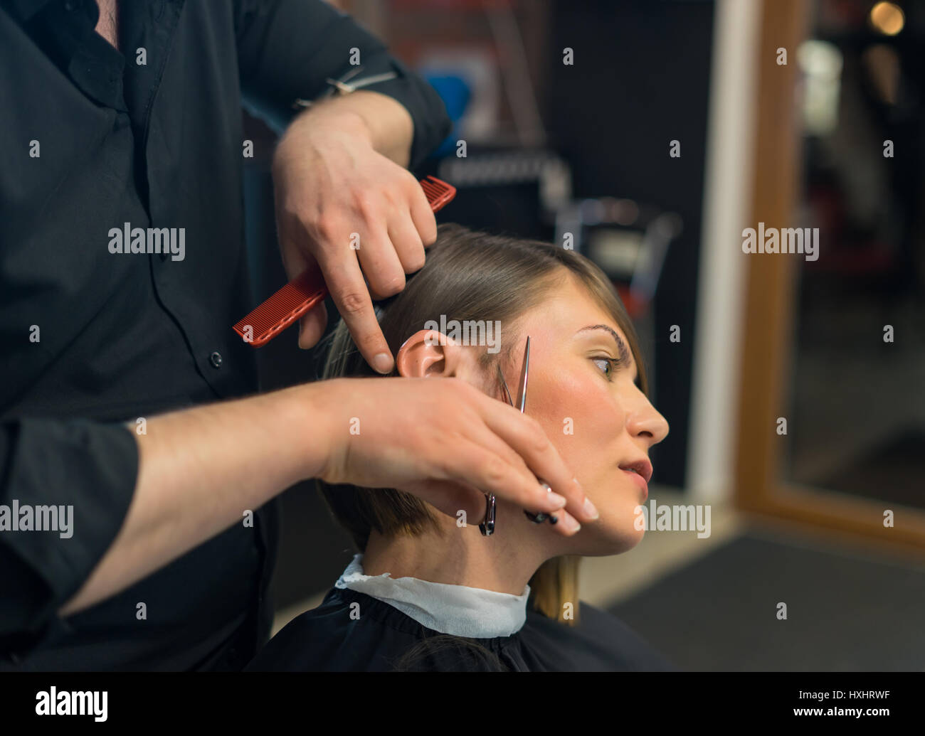 Coiffure masculine ne une coupe de jolie femme dans le salon de beauté. Banque D'Images