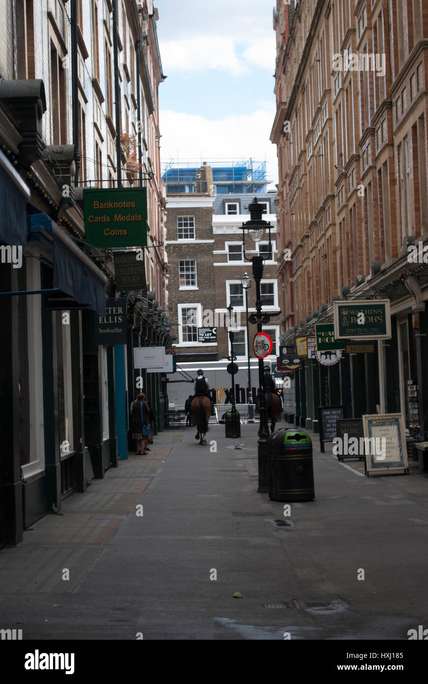 Cecil Court de Londres qui a été l'inspiration pour le chemin de traverse dans J K Rowling Harry Potter avec deux chevaux de la police dans la distance Banque D'Images