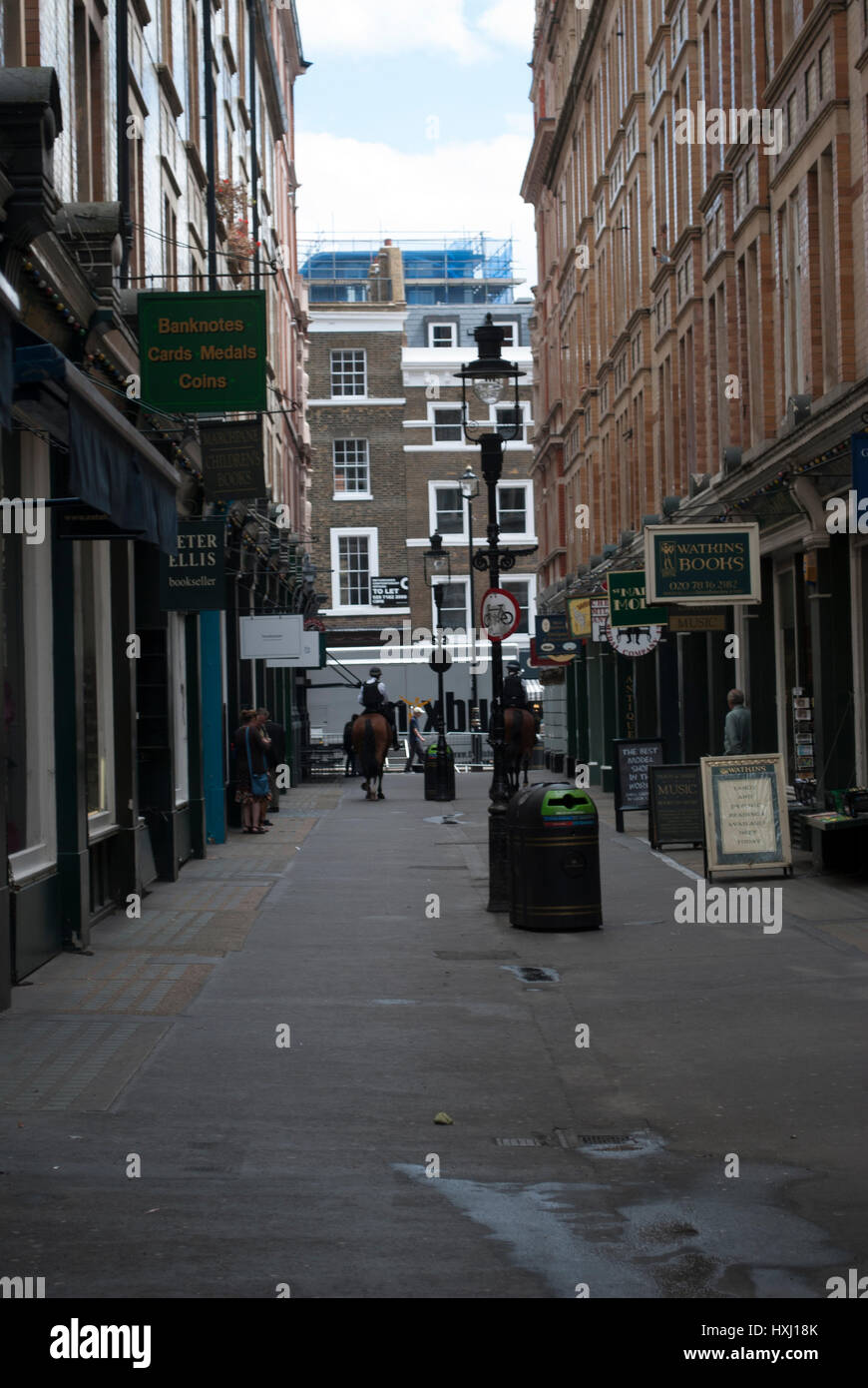 Cecil Court de Londres qui a été l'inspiration pour le chemin de traverse dans J K Rowling Harry Potter avec deux chevaux de la police dans la distance Banque D'Images