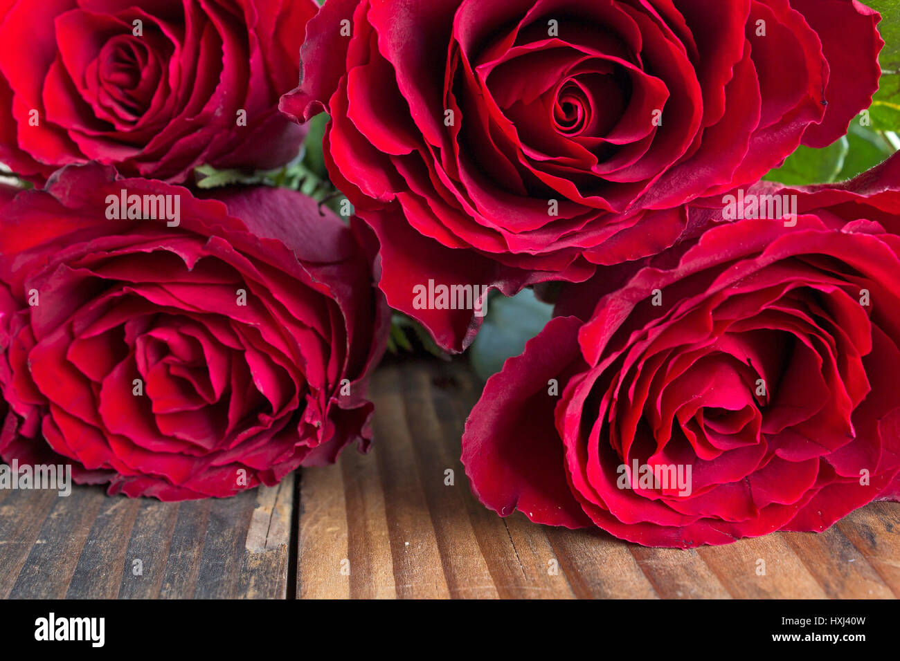 Bouquet de roses rouges sur une table en bois rustique. Banque D'Images