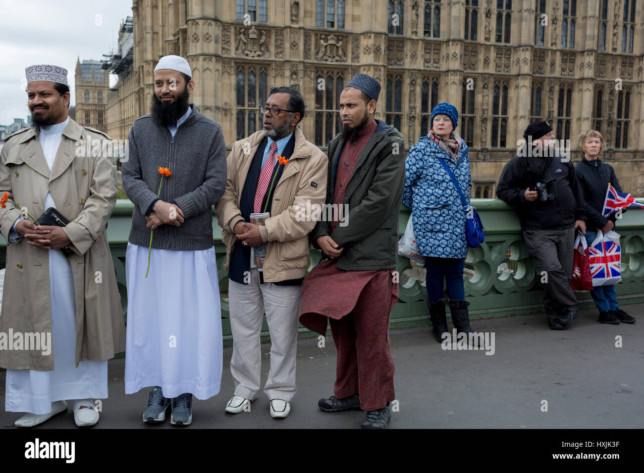 Londres, Royaume-Uni. 28 mars 2017. La police de London et recueillir de Westminster Bridge, la scène de l'attaque terroriste il y a 7 jours où 4 personnes sont mortes et d'autres sévèrement blessés, le 29 mars 2017, Londres, Angleterre. Des centaines a traversé la Tamise dans une veillée silencieuse pour commémorer ceux qui sont morts à 2.40pm lorsque Khalid Masood a poussé sur la foule sur le pont avant d'avoir poignardé un policier à la proximité du Palais de Westminster. La foule se tut, beaucoup s'inclinant la tête, parmi eux se trouvaient des dizaines de jeunes enfants musulmans et des membres de la Communauté Ahmadiyya. © Richard Baker/Alamy Live News Banque D'Images