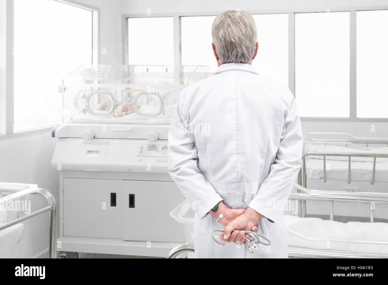 Senior doctor with stethoscope à à nouveau-né en incubateur à l'intérieur chambre après livraison Banque D'Images