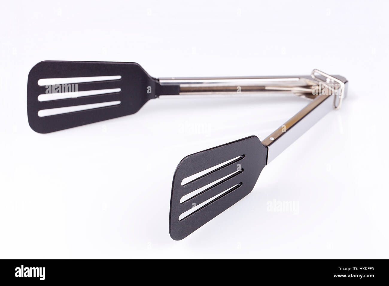 Pinces sur une surface blanche. Outil de cuisine isolé sur fond blanc. Banque D'Images