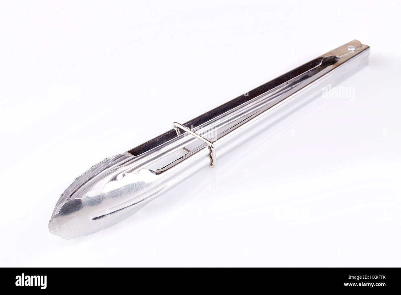 Pinces sur une surface blanche. Outil de cuisine isolé sur fond blanc. Banque D'Images
