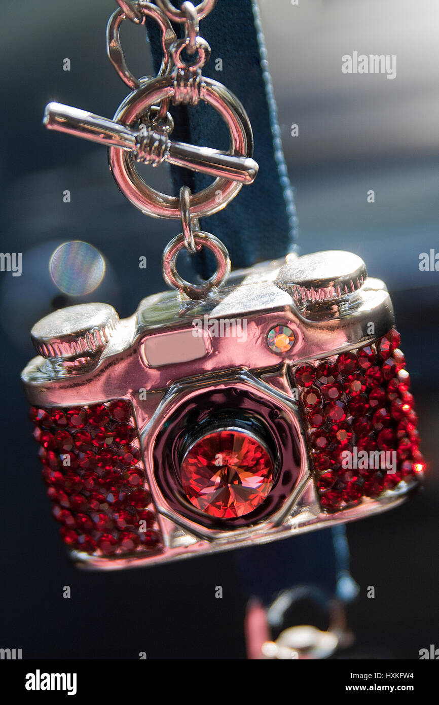 Mini caméra avec collier de pierres rouges. Banque D'Images