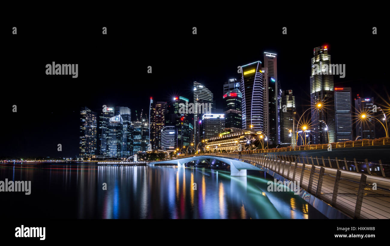 Vue de nuit du pont du Jubilé et le paysage urbain de la gratte-ciel du quartier des affaires de Singapour ville prises d'un bout à Marina Bay, Singapour City Banque D'Images