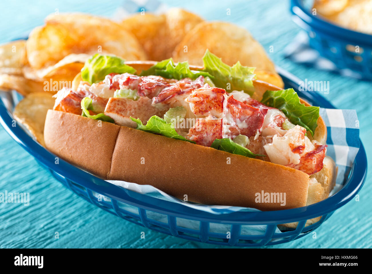 Un délicieux rouleau de homard avec de la laitue, le céleri, la mayonnaise, et croustilles de pommes de terre. Banque D'Images