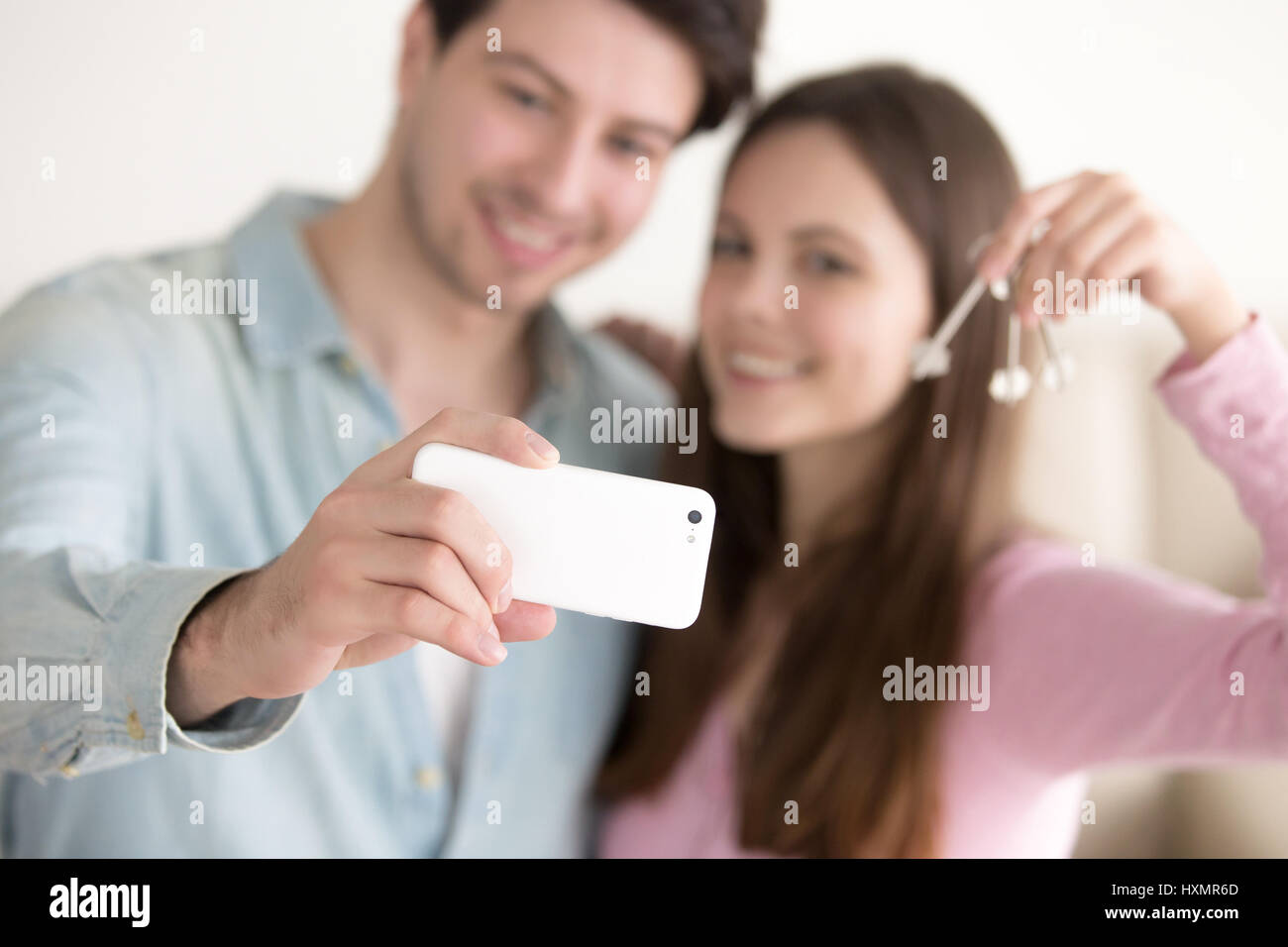 Young couple holding smartphone selfies en utilisant les touches pour l'apar Banque D'Images