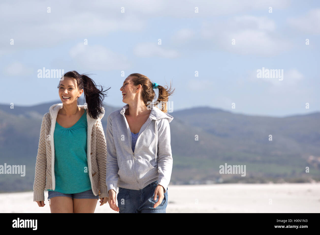 Portrait de deux amis marchant sur la plage smiling Banque D'Images